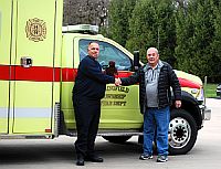 Fire Chief Dave Nangle receives a donated teddy bear from Marc Turner